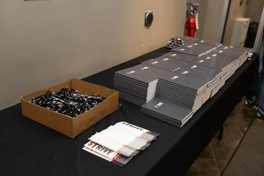 Strive notebooks, name tags, and pens ready for attendees