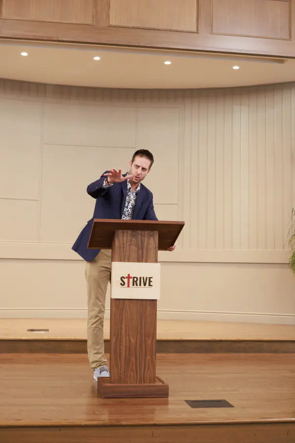A speaker gesturing during a 2025 Strive conference session