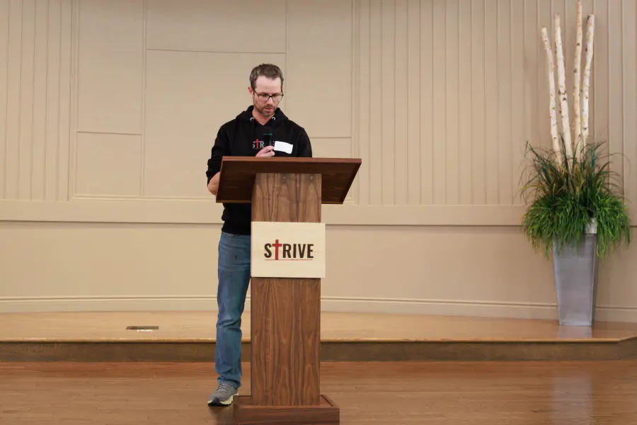 A Strive organizer reading from the podium